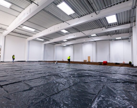 Warehouse construction site. Building a new industrial hall. Worker and engineers walking.